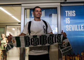 Romain Perraud en el aeropuerto de Sevilla posa con la bufanda de Real Betis | Imagen: Mario Míjenz -ZM