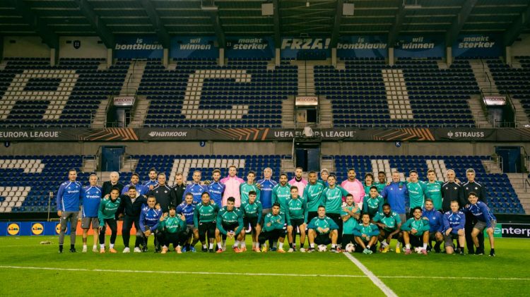 Plantilla del Real Betis posando sobre el césped del Cegeka Arena, estadio del Genk. | Imagen: perfil de X @RealBetis.