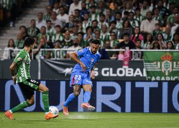 Nico González (Atlético de Madrid) centra ante Marc Bartra (Real Betis)