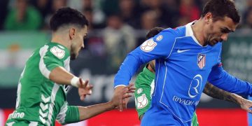 Marc Bartra disputando el balón con Griezmann en el Betis - Atlético de Madrid. | Imagen: perfil de X @Atleti.