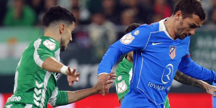Marc Bartra disputando el balón con Griezmann en el Betis - Atlético de Madrid. | Imagen: perfil de X @Atleti.