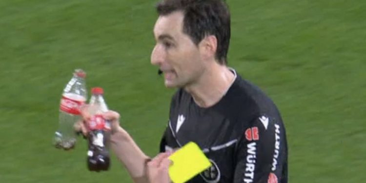 Ricardo de Burgos Bengoetxea con las dos botellas que se tiraron en el Betis-Sevilla y que aparecen en el acta. | Imagen: X.
