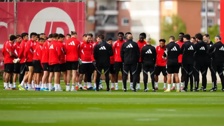 Plantilla del Sevilla escuchando una charla en el entrenamiento. | Imagen: página web Sevilla FC.