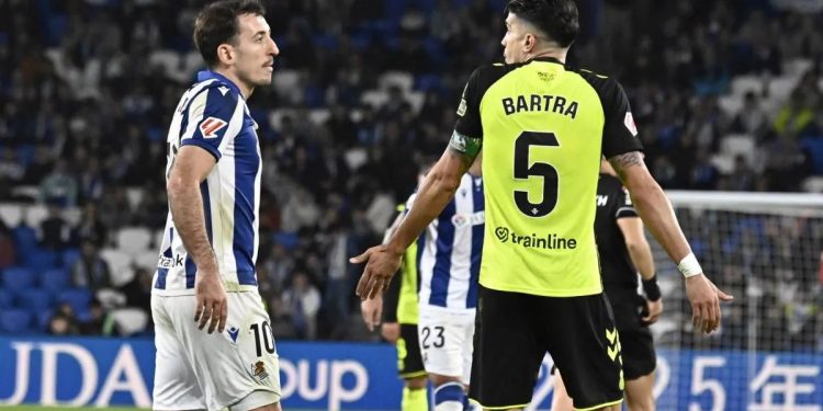 Oyarzabal dialogando con Marc Bartra durante un Real Sociedad-Betis. | Imagen: perfil de X @ZonaMixta__.